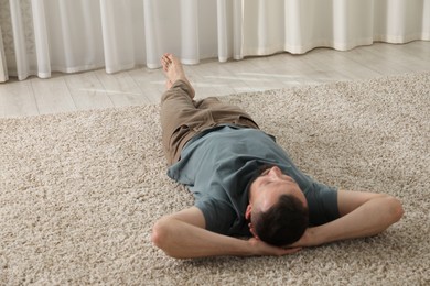 Photo of Harmony. Man lying on rug at home