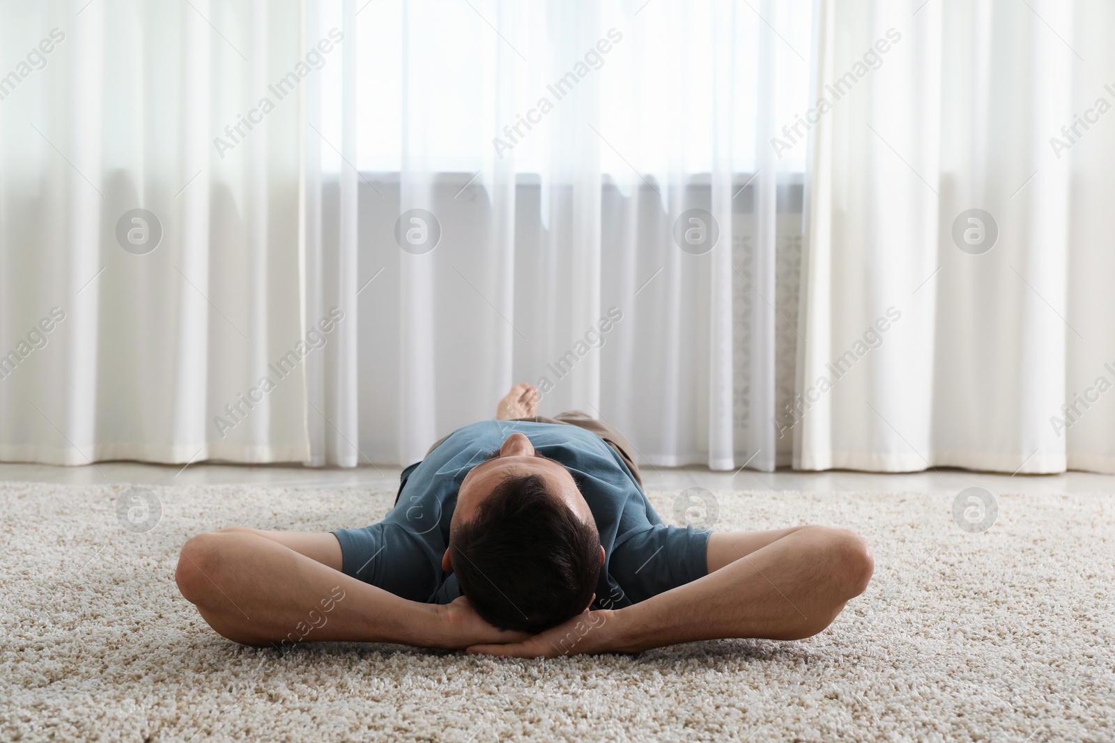 Harmony. Man lying on rug at home Photo of Harmony. Man lying on rug at home