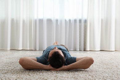 Photo of Harmony. Man lying on rug at home