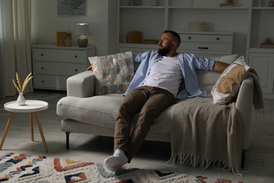 Photo of Harmony. Man relaxing on comfortable sofa at home