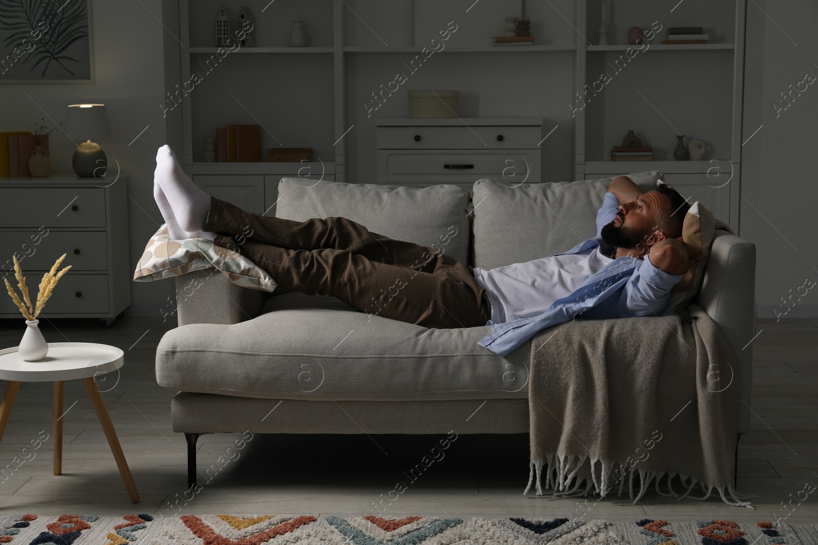Photo of Harmony. Man relaxing on comfortable sofa at home