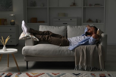 Photo of Harmony. Man relaxing on comfortable sofa at home