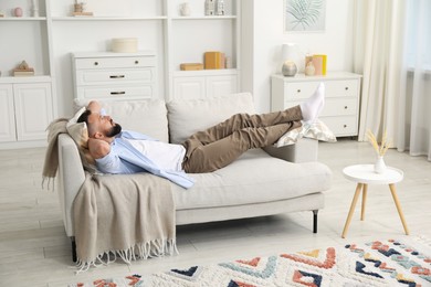 Photo of Harmony. Man relaxing on comfortable sofa at home