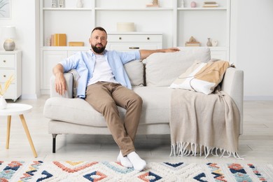Photo of Harmony. Man relaxing on comfortable sofa at home