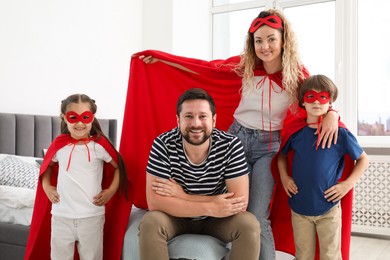 Photo of Portrait of parents and children in superhero costumes at home