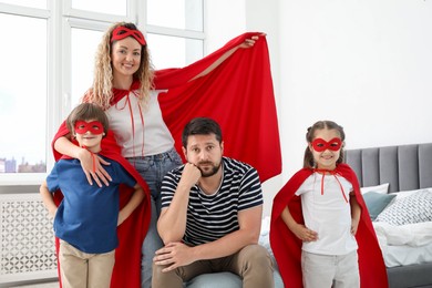 Photo of Portrait of parents and children in superhero costumes at home