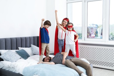 Photo of Parents and children in superhero costumes playing at home