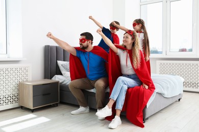 Photo of Parents and children in superhero costumes playing at home