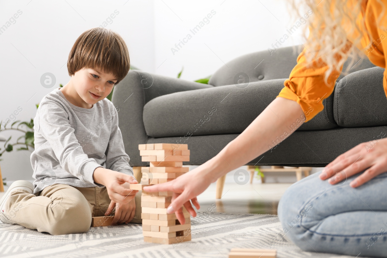 Mother and her son playing with wooden constructor blocks on floor at home, closeup Photo of Mother and her son playing with wooden constructor blocks on floor at home, closeup