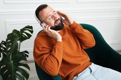 Photo of Harmony. Man listening to music in headphones at home