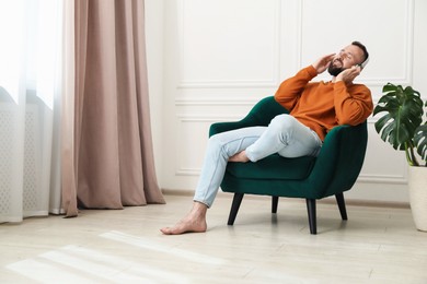 Photo of Harmony. Man listening to music in headphones at home
