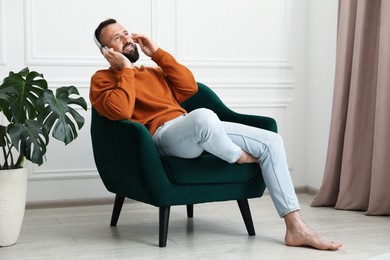 Photo of Harmony. Man listening to music in headphones at home
