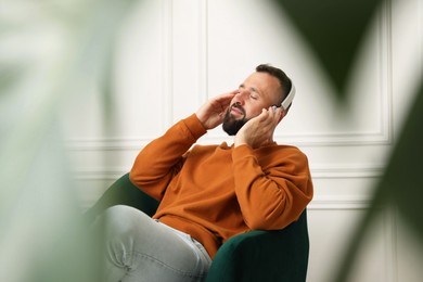 Photo of Harmony. Man listening to music in headphones at home