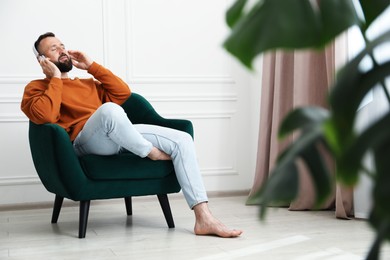 Photo of Harmony. Man listening to music in headphones at home