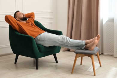 Photo of Harmony. Man relaxing in comfortable armchair at home