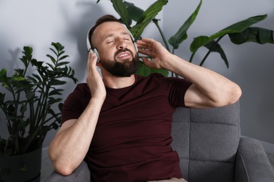 Photo of Harmony. Man listening to music in headphones at home