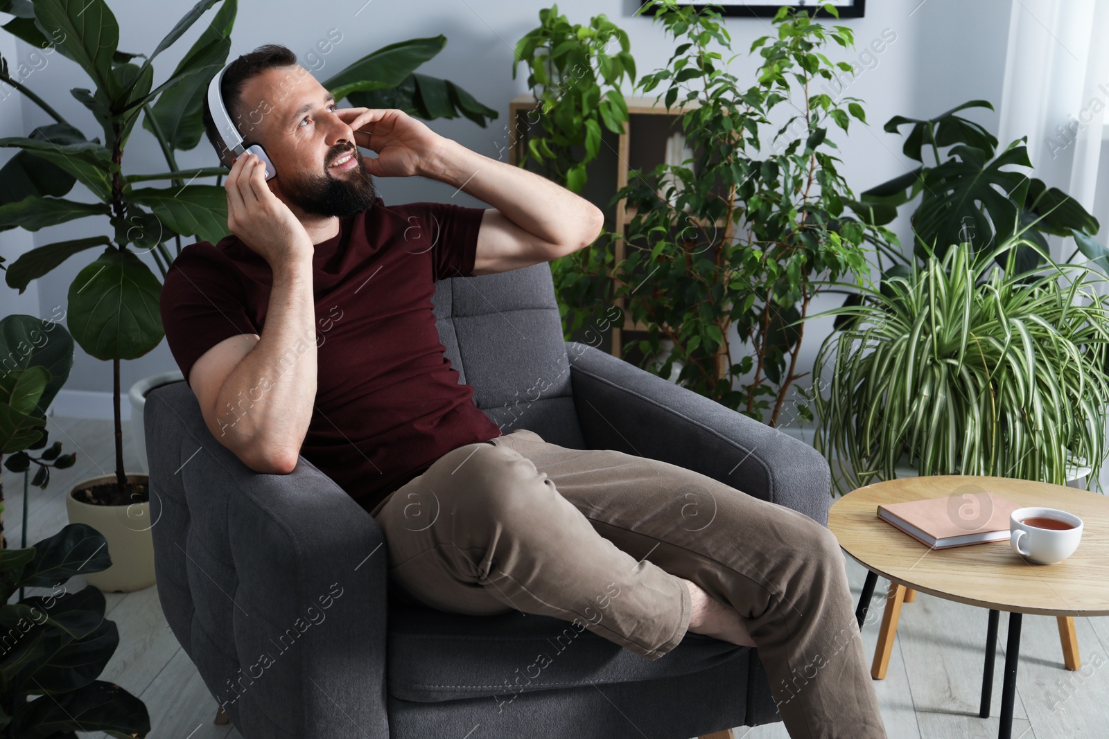 Photo of Harmony. Man listening to music in headphones at home