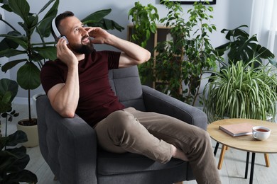 Photo of Harmony. Man listening to music in headphones at home