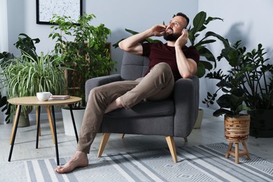 Photo of Harmony. Man listening to music in headphones at home
