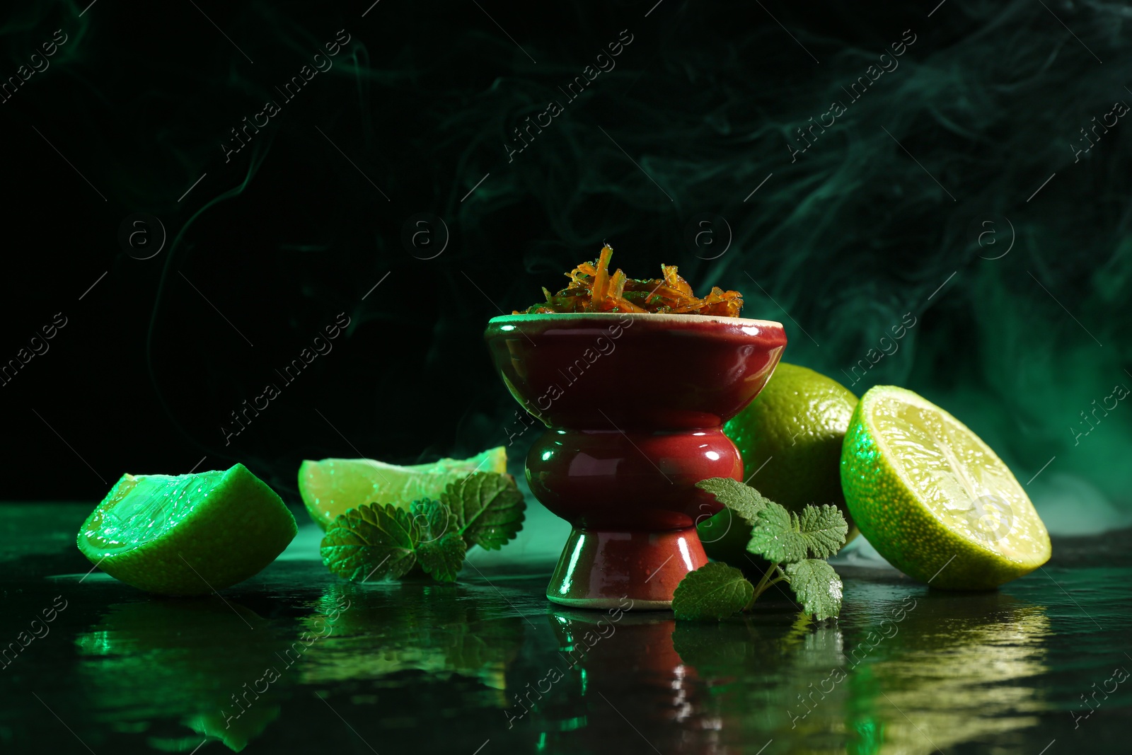 Hookah bowl with limes, mint and smoke on black table, closeup Photo of Hookah bowl with limes, mint and smoke on black table, closeup