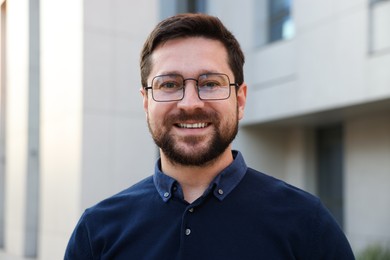 Photo of Portrait of happy businessman near office building