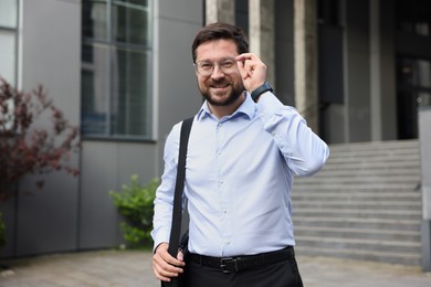 Photo of Portrait of successful businessman near office building