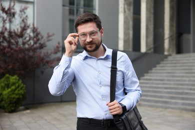 Photo of Portrait of successful businessman near office building