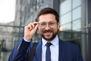 Photo of Portrait of successful businessman near office building