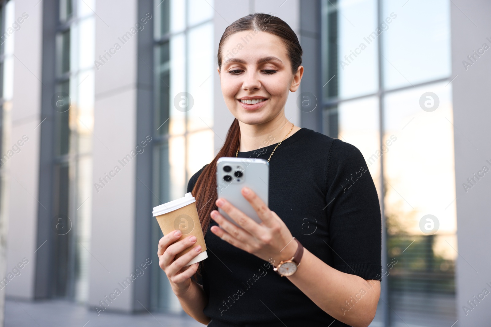Photo of Successful businesswoman with coffee and smartphone near office building