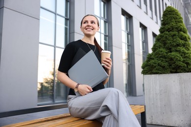 Photo of Successful businesswoman with coffee and folder near office building