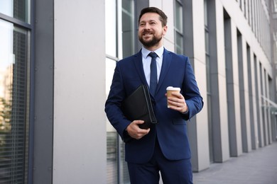 Photo of Successful businessman with coffee near office building