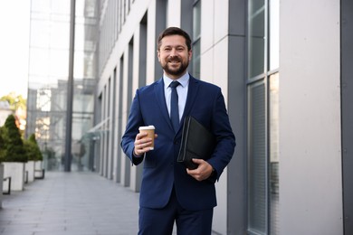 Photo of Successful businessman with coffee near office building