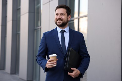 Photo of Successful businessman with coffee near office building