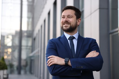 Photo of Portrait of successful businessman near office building. Space for text