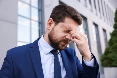 Photo of Portrait of tired businessman outside office building
