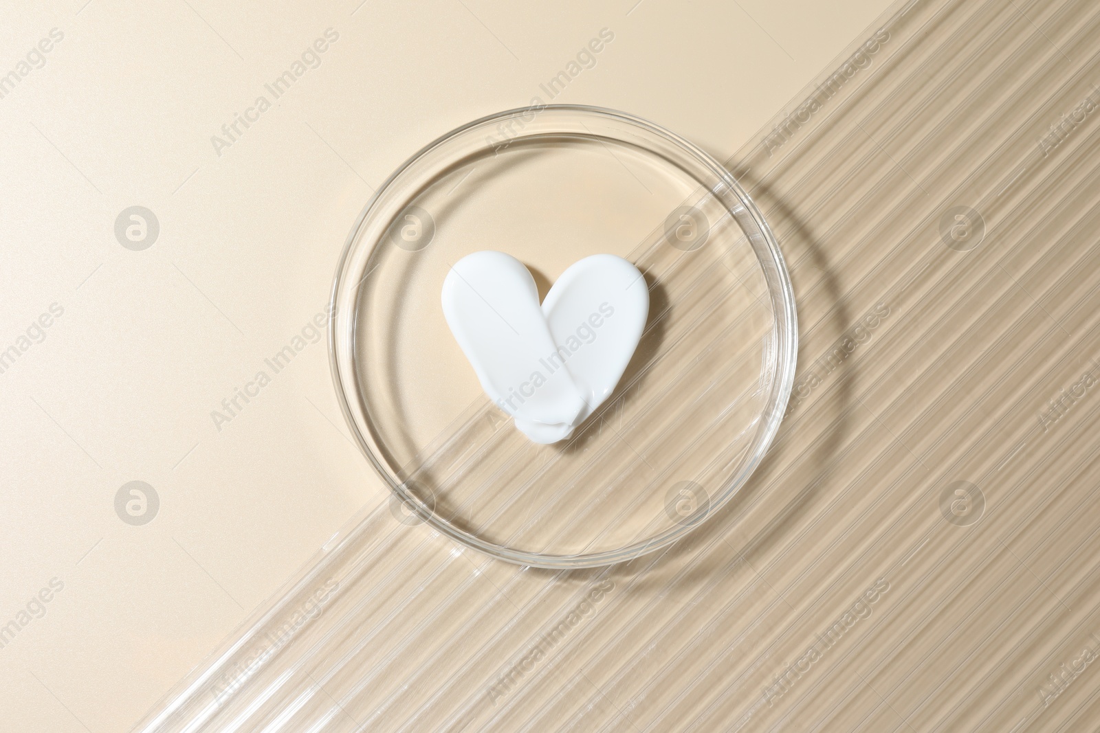 Cosmetic product in Petri dish on beige background, top view Photo of Cosmetic product in Petri dish on beige background, top view