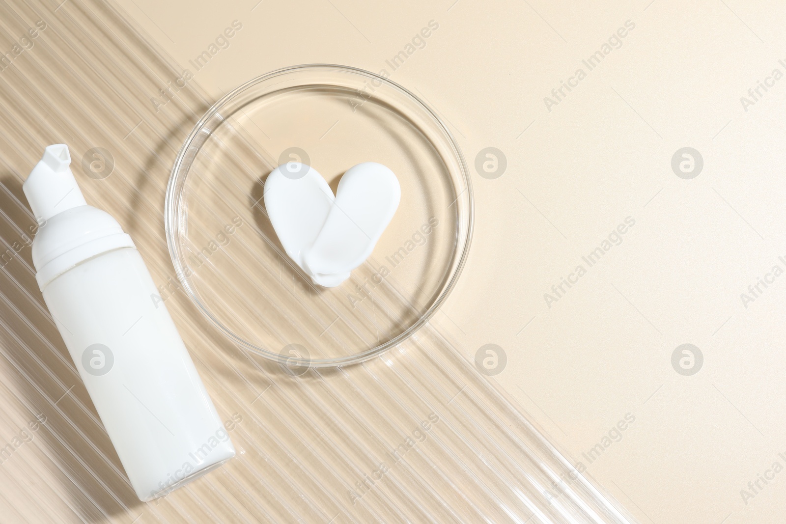 Cosmetic product in Petri dish and bottle on beige background, top view. Space for text Photo of Cosmetic product in Petri dish and bottle on beige background, top view. Space for text