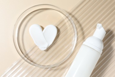 Photo of Cosmetic product in Petri dish and bottle on beige background, top view