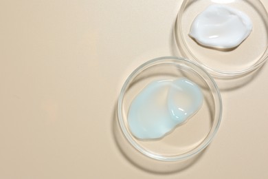 Photo of Different cosmetic products in Petri dishes on beige background, flat lay. Space for text