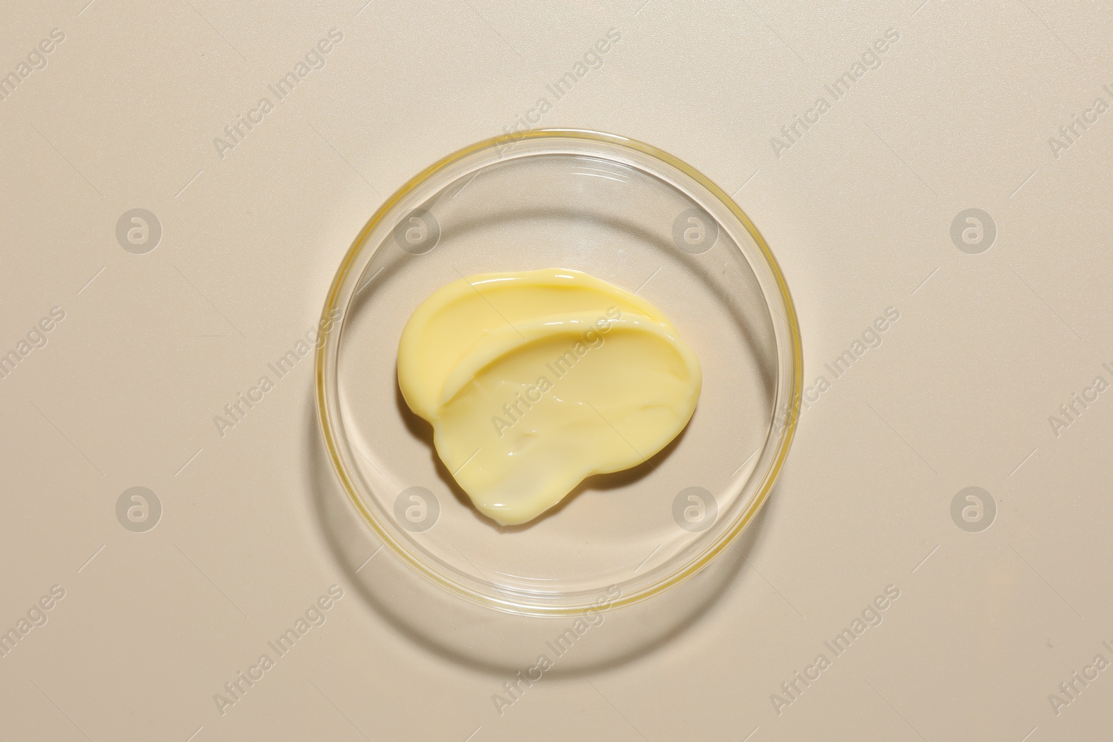 Cosmetic product in Petri dish on beige background, top view Photo of Cosmetic product in Petri dish on beige background, top view
