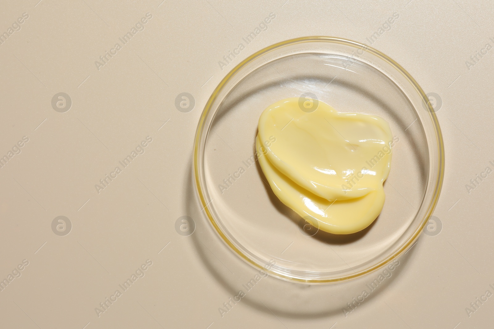 Cosmetic product in Petri dish on beige background, top view. Space for text Photo of Cosmetic product in Petri dish on beige background, top view. Space for text