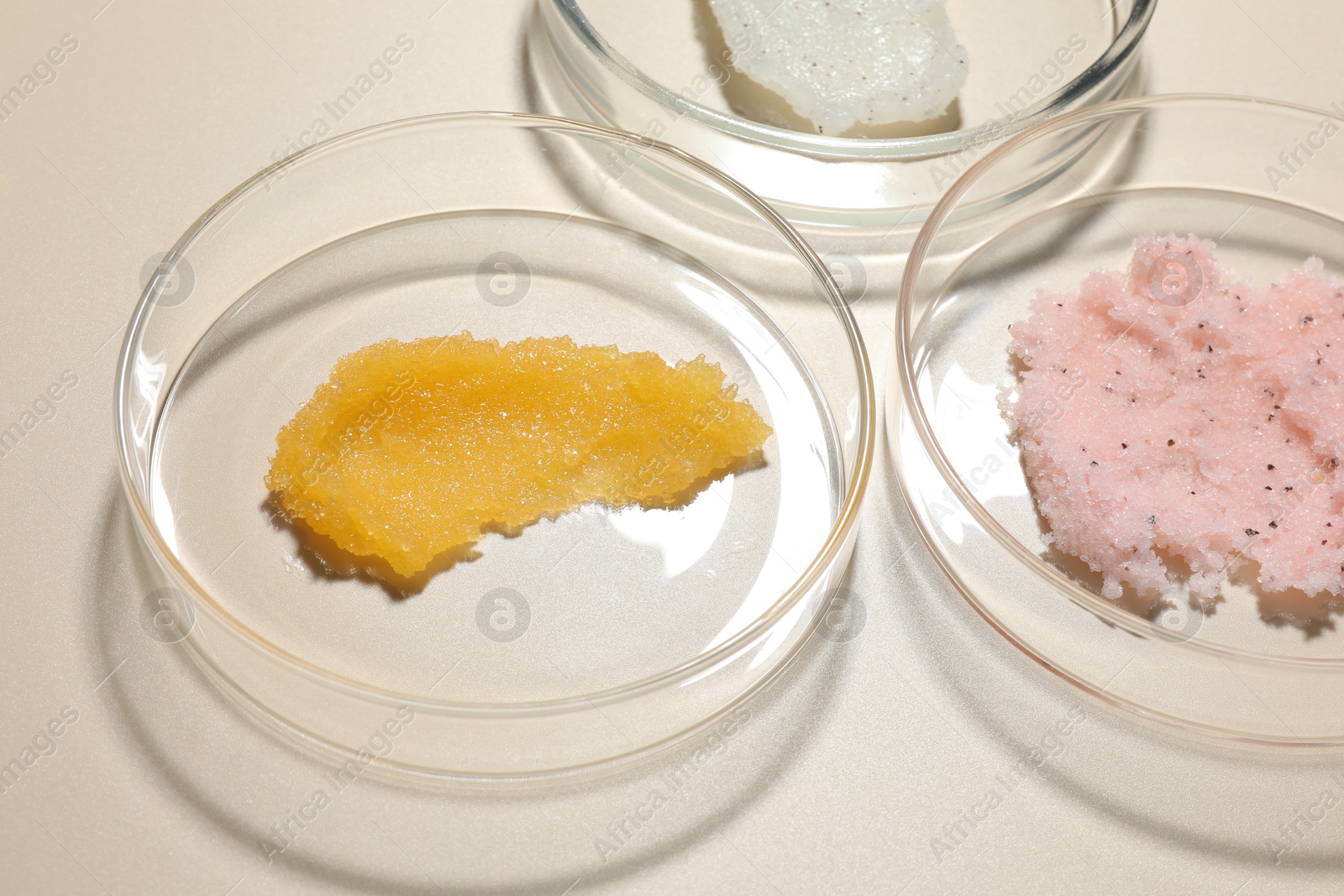 Different cosmetic products in Petri dishes on beige background, closeup Photo of Different cosmetic products in Petri dishes on beige background, closeup