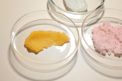 Photo of Different cosmetic products in Petri dishes on beige background, closeup