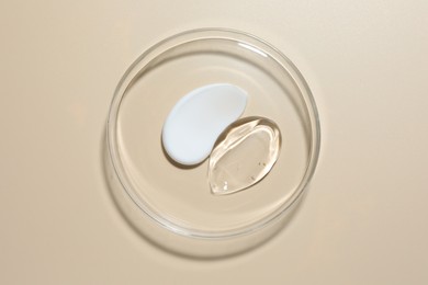 Photo of Different cosmetic products in Petri dish on beige background, top view