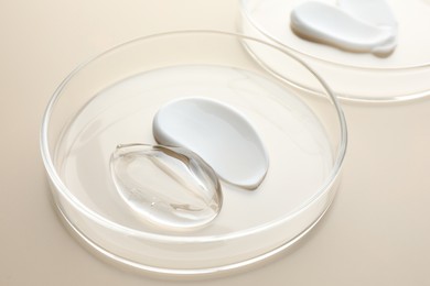Photo of Different cosmetic products in Petri dishes on beige background, closeup