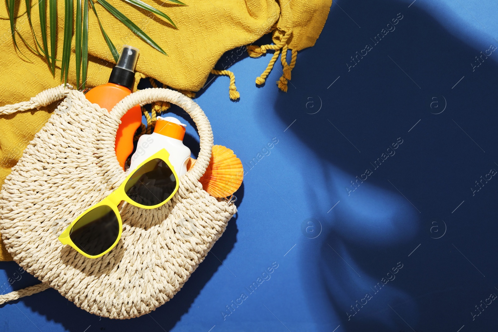 Beach accessories and palm leaf on blue background, flat lay. Space for text Photo of Beach accessories and palm leaf on blue background, flat lay. Space for text
