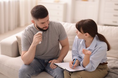 Photo of Professional psychologist working with patient on sofa in office