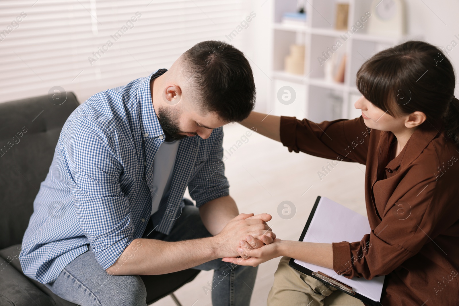 Photo of Psychologist supporting patient during therapy session in office