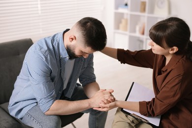 Photo of Psychologist supporting patient during therapy session in office