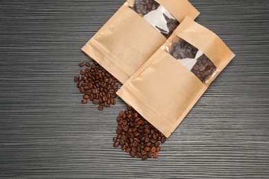 Photo of Zipper stand-up pouches and coffee beans on black textured table, flat lay. Mockup for design